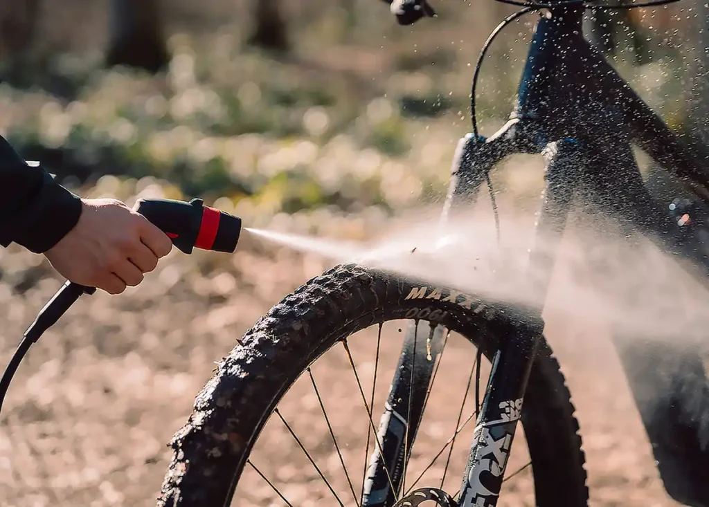 Limpieza de la rueda delantera de una bicicleta de montaña con una hidrolimpiadora portátil